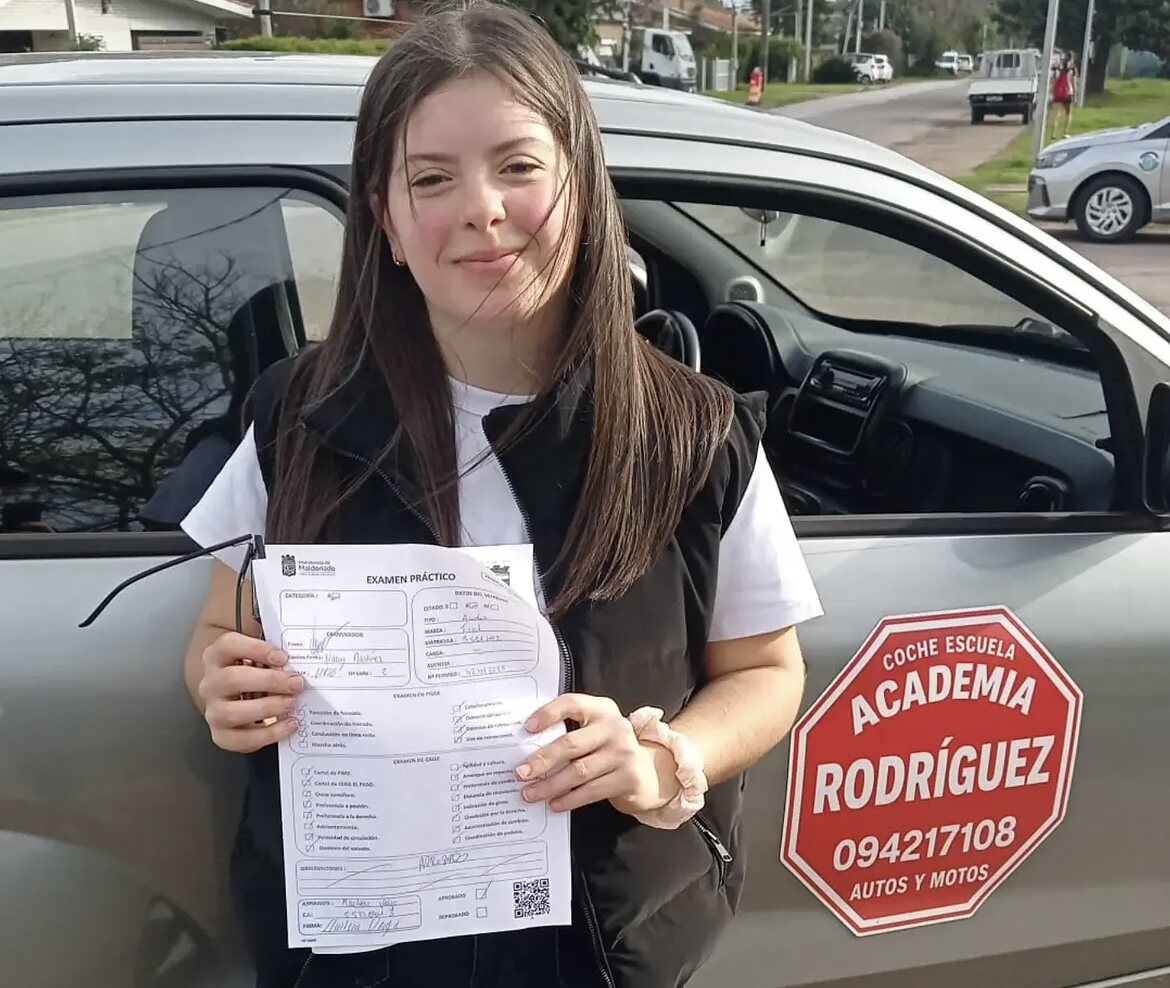 Alumna de Academia Rodríguez junto al coche escuela, con su examen práctico aprobado